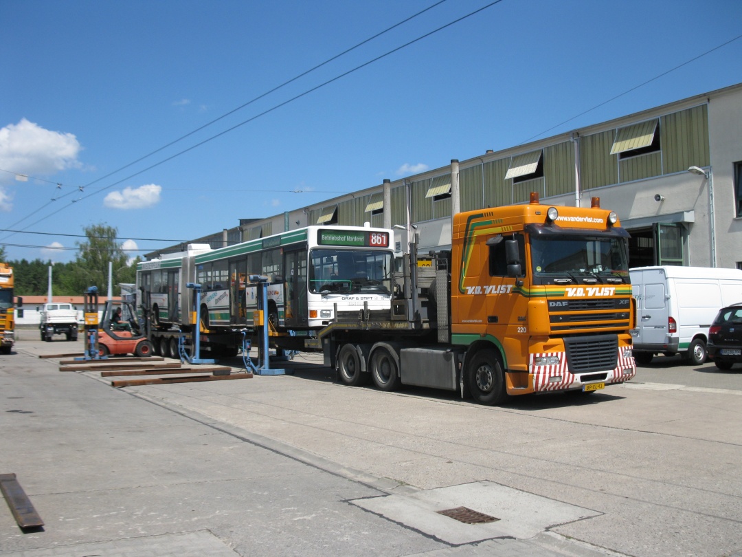 Der Gelenkobus 031 steht auf dem LKW-Tieflader. Die Verladetraversen werden entfernt.