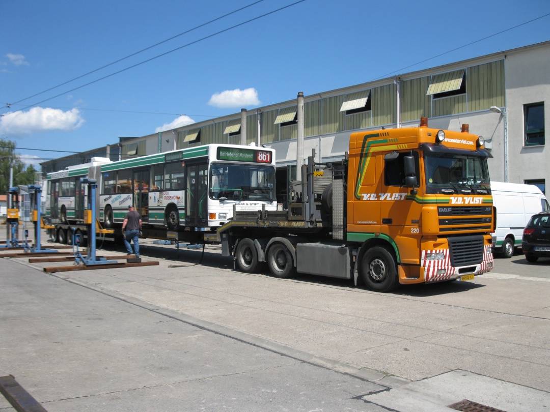 Die LKW-Fahrer sichern mittels Spanngurten den Gelenkobus.